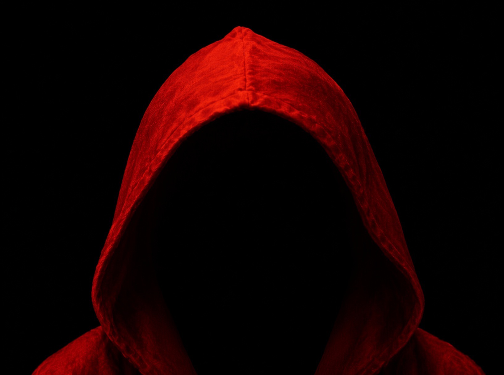Council member wearing the red hooded profile picture on a black background